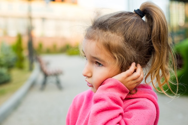 Een klein meisje in een roze hoodie