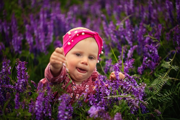 Een klein meisje in een veld met paarse bloemen