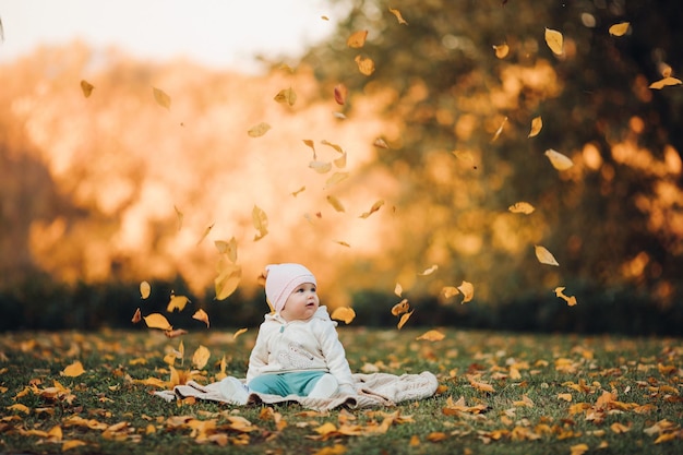 Een klein meisje in het herfstpark glimlacht en brengt tijd door mooie herfstachtergrond