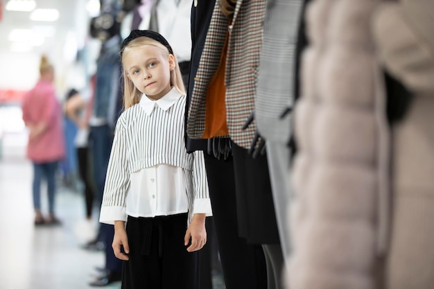 Een klein meisje in het midden van een pop in een winkel