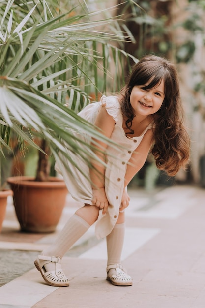 een klein meisje loopt in de botanische tuin gelukkige baby en palmbomen