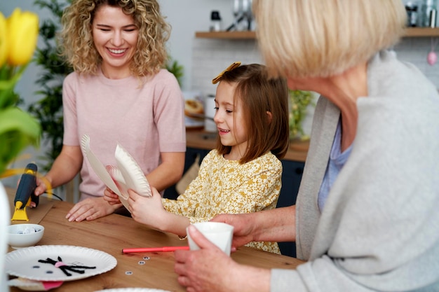Een klein meisje maakt een paaskonijn met de familie.