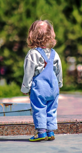 Een klein meisje met windhaar in het park.