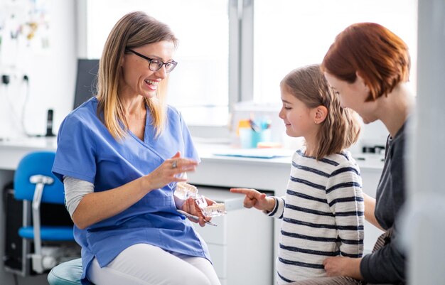 Een klein meisje moeder en tandarts in de chirurgie tandheelkundige controle