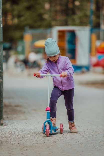 Een klein meisje speelt in het park. Het concept van familie socialiseren in het park. Een meisje schommelt op een schommel, speelt creatieve spelletjes.