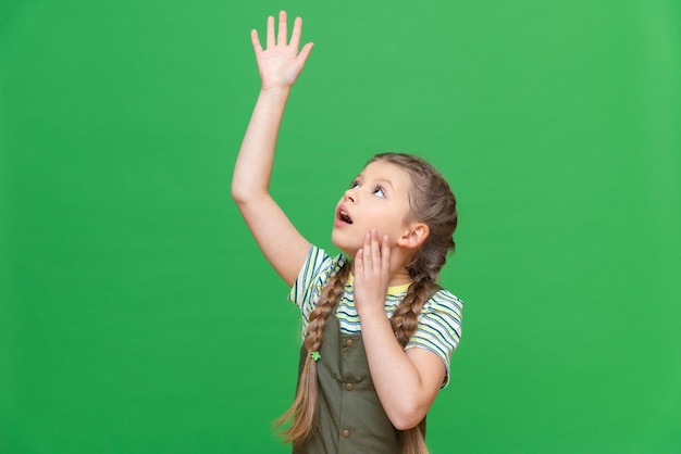 Een klein meisje strekte haar hand uit tegen een groene geïsoleerde achtergrond