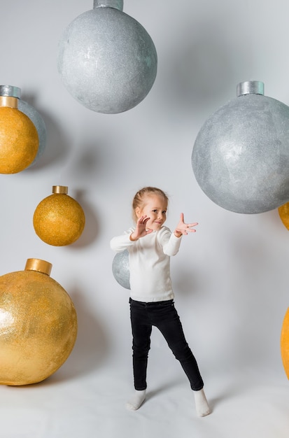 Een klein meisje toont een tovenaar met gigantische kerstballen