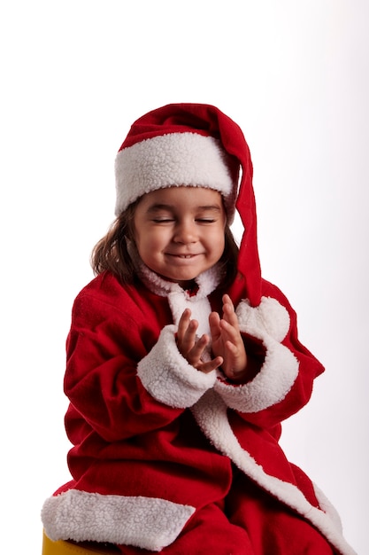 Een klein meisje verkleed als kerstman op een witte achtergrond