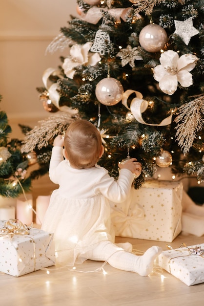 Een klein meisje versiert een kerstboom op haar eerste nieuwjaarxA