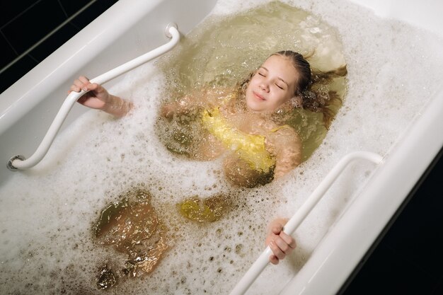 Een klein meisje volgt de procedure in een mineraalbad.