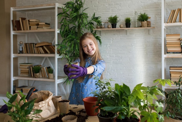 Een klein meisje zorgt voor bloemen, kijkt en bewondert een bloem