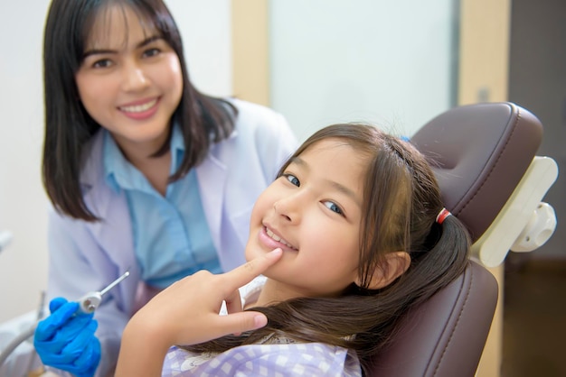 Een klein schattig meisje met tanden onderzocht door tandarts in tandheelkundige kliniek tandencontrole en gezond gebit concept