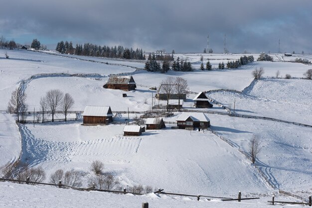 Een klein winterdorpje in de bergen bedekt met sneeuw.