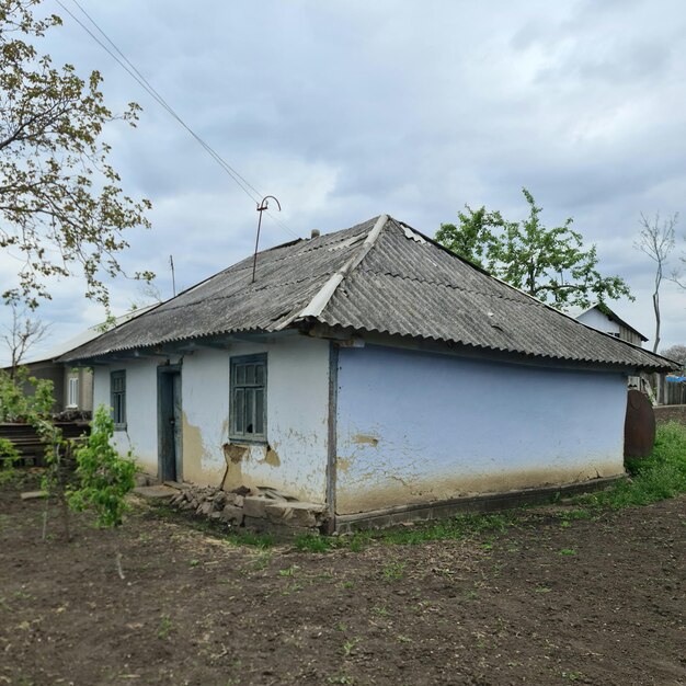 Een klein wit huis met een grijs dak en een grijs dak.