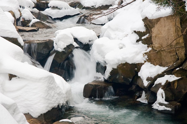 een kleine actieve waterval schone bergstroom besneeuwde winterlandschap wildlife achtergrond