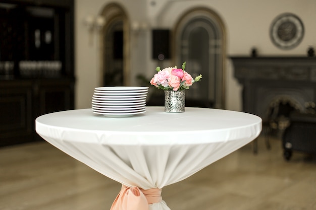 Een kleine bijzettafel in het restaurant, waarop lege glazen en borden staan