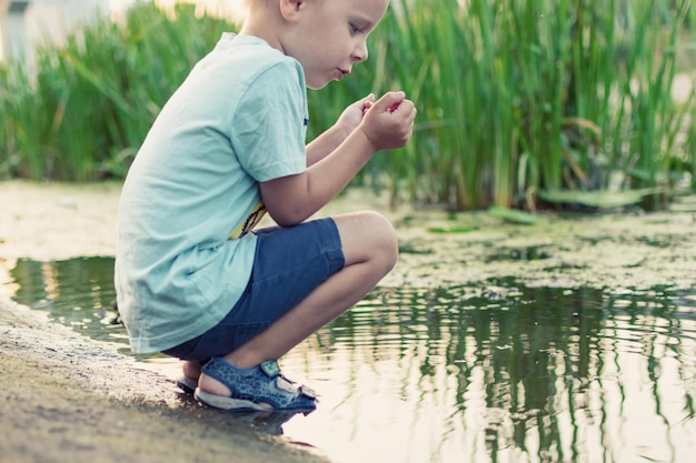 Een kleine jongen bij de vijver