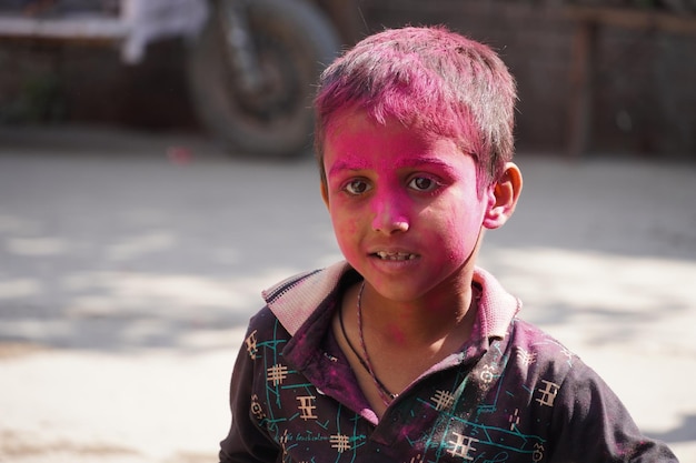 Een kleine jongen die heilig speelt met roze kleur 08 maart 2023 Vrindavan Uttar Pradesh 281121