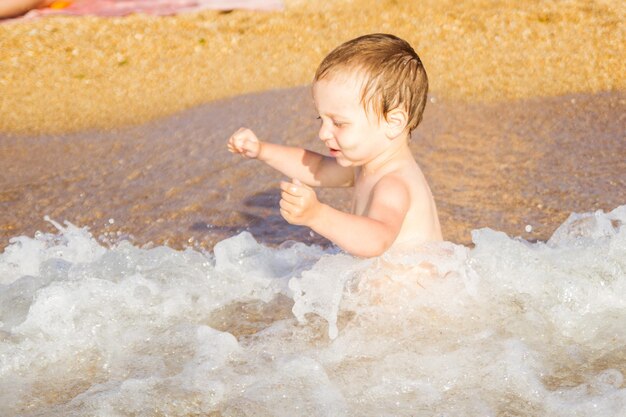 Een kleine jongen die plezier heeft in de zee op de golven