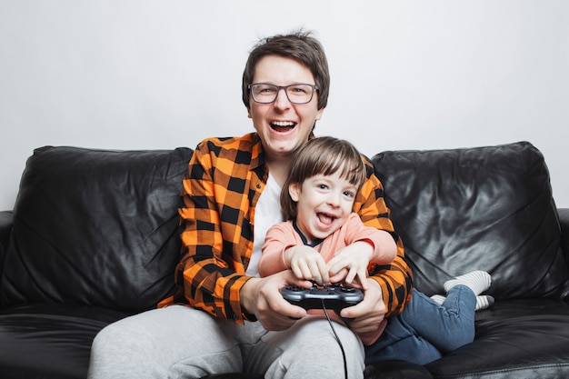 Een kleine jongen die videospelletjes met papa speelt.