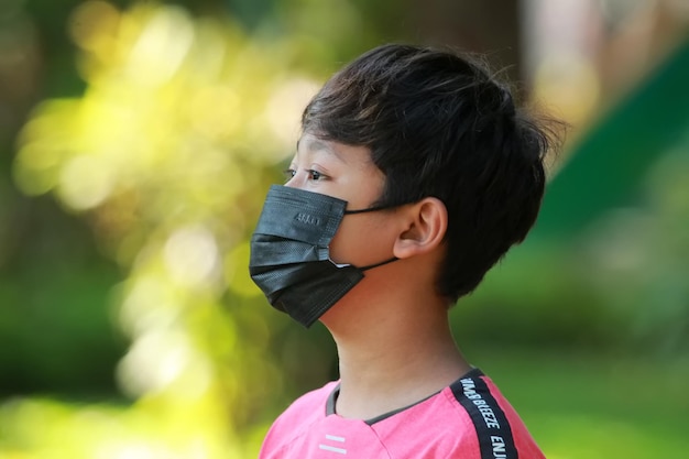 Foto een kleine jongen draagt een medisch masker ter bescherming tegen vervuiling