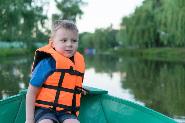 Een kleine jongen in een reddingsvest in een boot