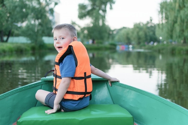 Een kleine jongen in een reddingsvest in een boot