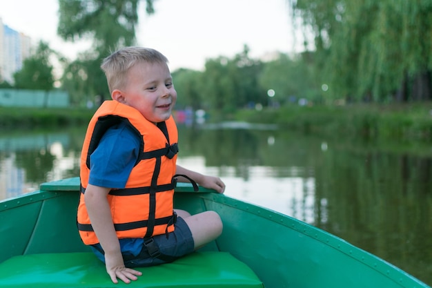 Een kleine jongen in een reddingsvest in een boot