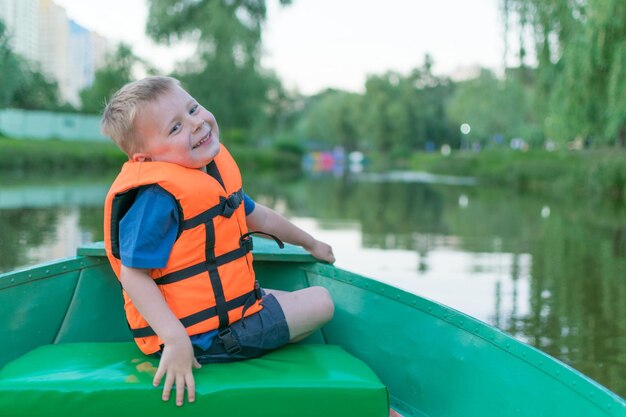 Een kleine jongen in een reddingsvest in een boot