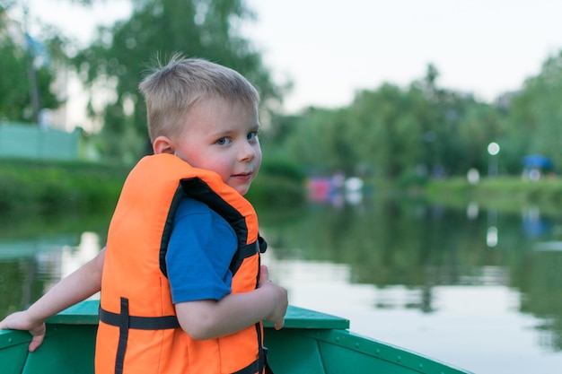 Een kleine jongen in een reddingsvest in een boot