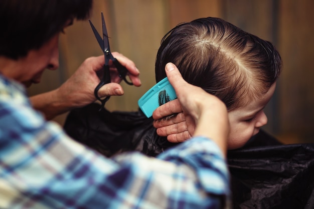 Een kleine jongen is getrimd in de felle emoties van de kapper op zijn gezicht