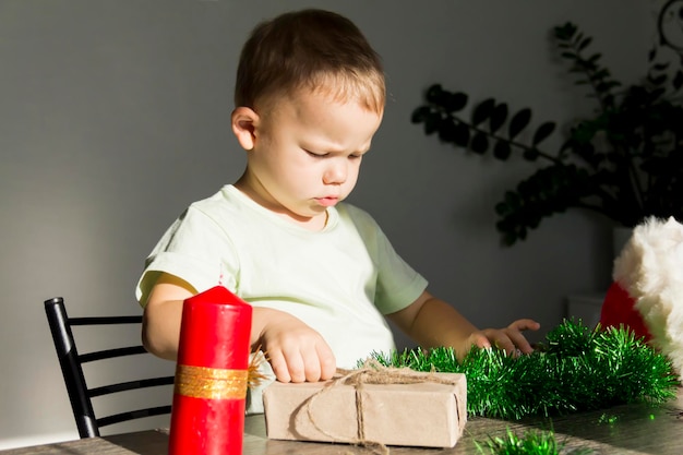 Een kleine jongen met cadeautjes aan de nieuwjaarstafel