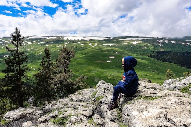 Een kleine jongen op de achtergrond van de alpenweiden van het LagoNaki-plateau in Adygea Rusland 2021