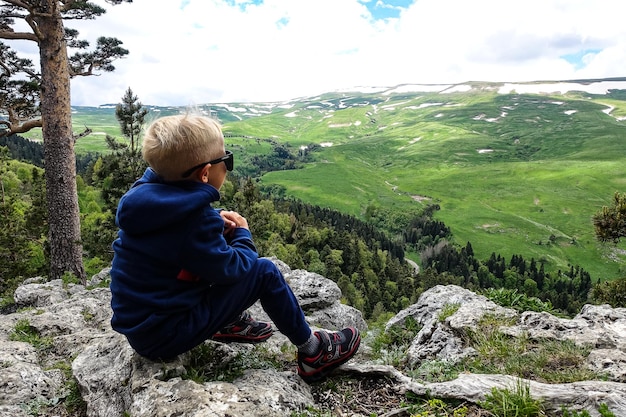 Een kleine jongen op de achtergrond van de alpenweiden van het LagoNaki-plateau in Adygea Rusland 2021