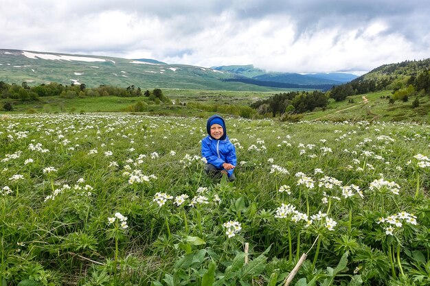 Een kleine jongen op de bloeiende alpenweiden van LagoNaki Adygea Rusland 2021