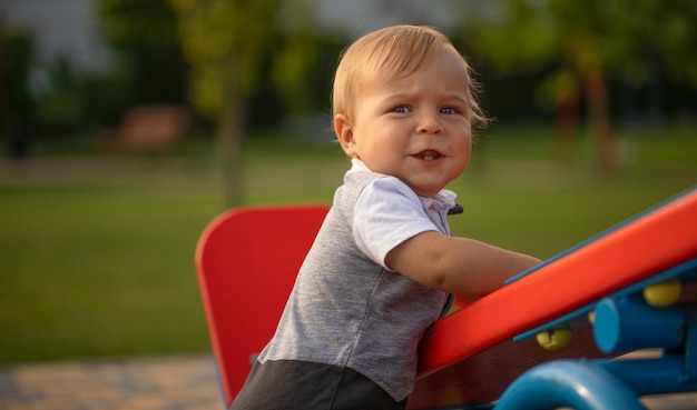 Een kleine jongen schommelt op een schommel op een mooie zomerdag