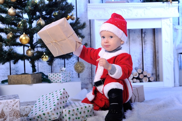 Een kleine kerstman met cadeautje onder de boom