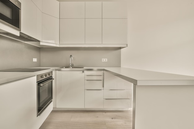 Een kleine keuken met moderne apparatuur in een wit design in een gezellig appartement