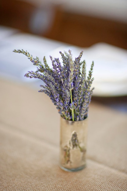 Een kleine pot met verse lavendelbloemen op een tafelblad