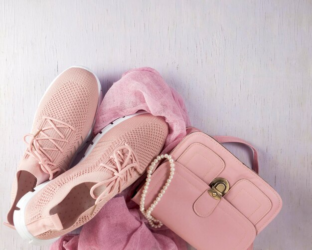 Een kleine roze handtas en lichte zomerschoenen Lay-out op tafel