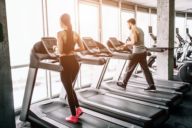 Een kleine weergave van een grote sportruimte waar twee mensen trainen. ze draaien op elliptische machines. de oefening is intensief en zwaar.