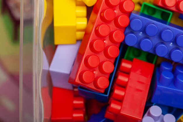 Een kleurrijke bouwset, die op de vloer van een huis ligt, close-up. Educatieve spelletjes voor kinderen. plastic kinderkubussen, selectieve aandacht.