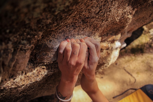 Een klimmer die een rots vasthoudt met zijn hand