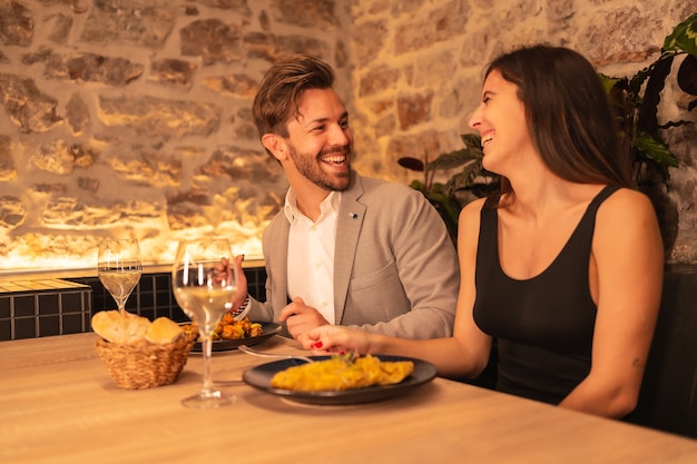 Een knap jong koppel verliefd in een restaurant, met plezier samen eten, Valentijn vieren