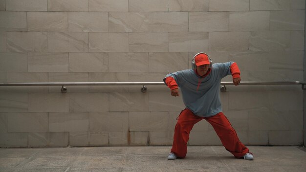 Foto een knappe choreograaf oefent straatdans op een grijze achtergrond.