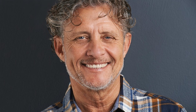 Een knappe glimlach Een bijgesneden portret van een gelukkige volwassen man die tegen een grijze achtergrond staat