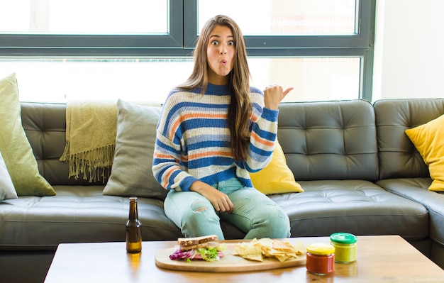 Een knappe vrouw die verbaasd en ongelovig kijkt, wijst naar het bezwaar op de zijkant