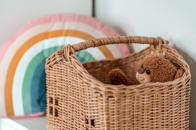 Een knuffelbeer zit in een rieten mand in de vorm van een huis, een kinderconcept