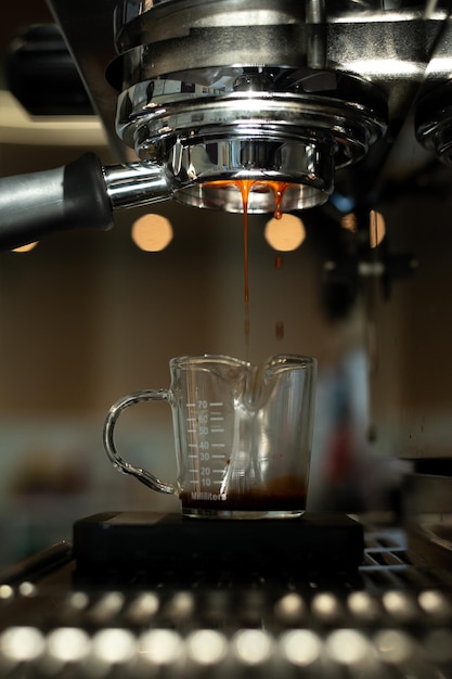 Een koffiekopje wordt in een glas gegoten.