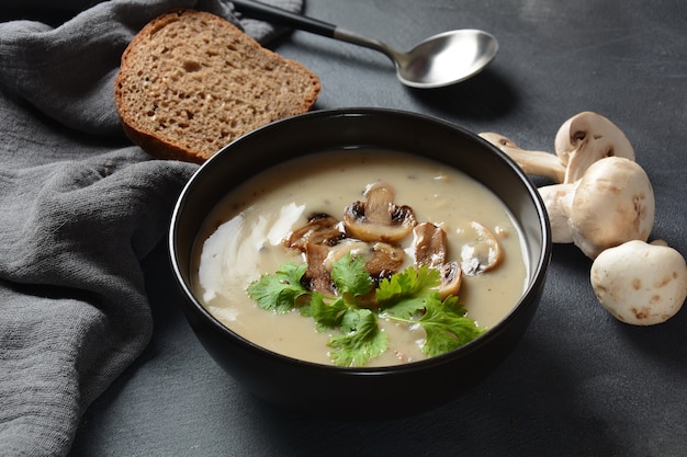 Een kom Champignonroomsoep met gebakken champignons en verse peterselie.